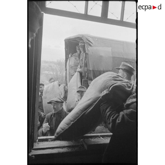 Déchargement de camions par des soldats allemands et des civils requis.