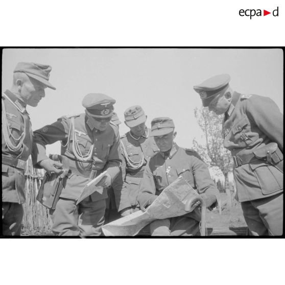 Un lieutenant-colonel (Oberstleutnant) étudiant une carte avec des officiers des troupes de montagne (Gebirgsjäger).
