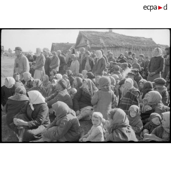 Un officier supérieur inspecte le front, les villageois semblent avoir été rassemblé pour la venue de l'autorité allemande