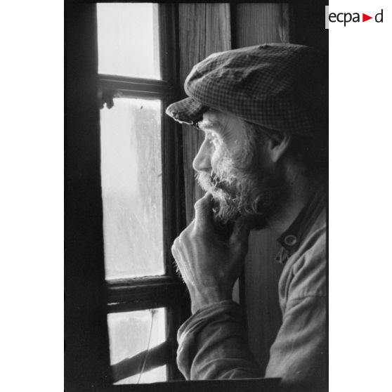 Portrait d'un villageois dans sa maison.
