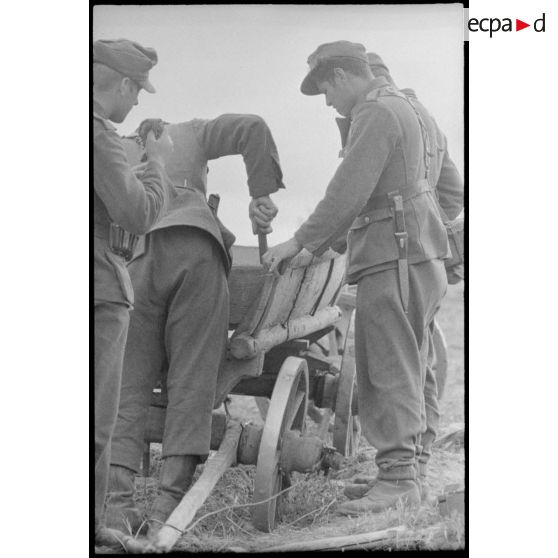 Des fantassins allemandes réparent une charrette qui transportera leurs effets personnels.