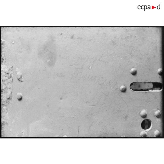 Inscriptions réalisées à la main sur des plaques métalliques, malheureusement assez peu lisibles.