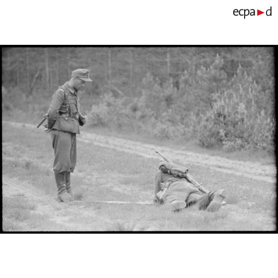 Un pionnier retire une mine sous les yeux d'un sous-officier.