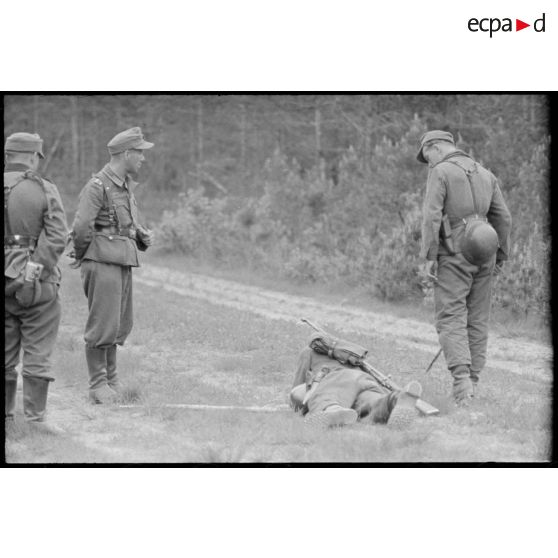 Un pionnier retire une mine sous les yeux d'un sous-officier.