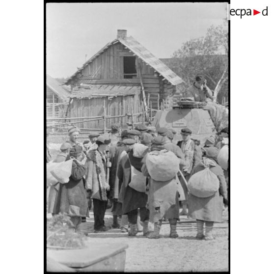 Durant l'opération Frühlingfest, des travailleurs forcés (Zwangarbeiter) accompagnent sous la contrainte des blindés légers allemands Panzer II.