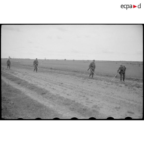 Des fantassins testent le sol à la recherche de mines.