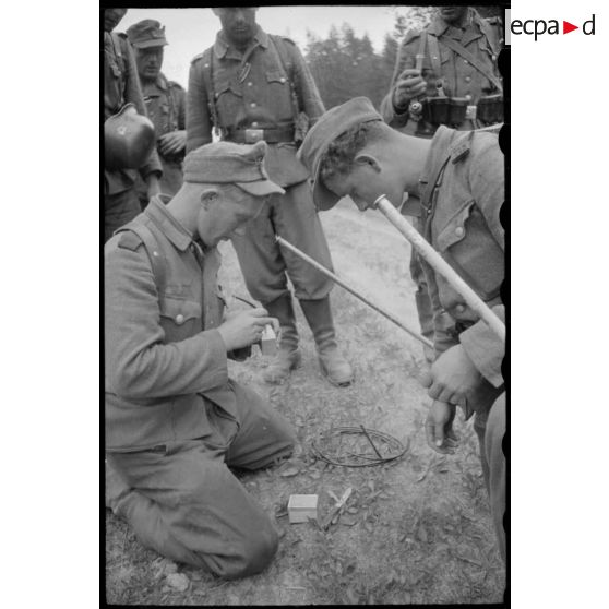 Des pionniers du Génie allemand fixent une mèche à de l'explosif.