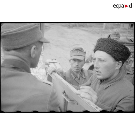 Un colonel cherche son chemin, il semble demander l'aide de soldats russes sous l'uniforme allemand.