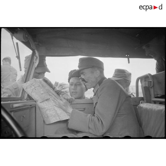 Un colonel cherche son chemin, il semble demander l'aide de soldats russes sous l'uniforme allemand.
