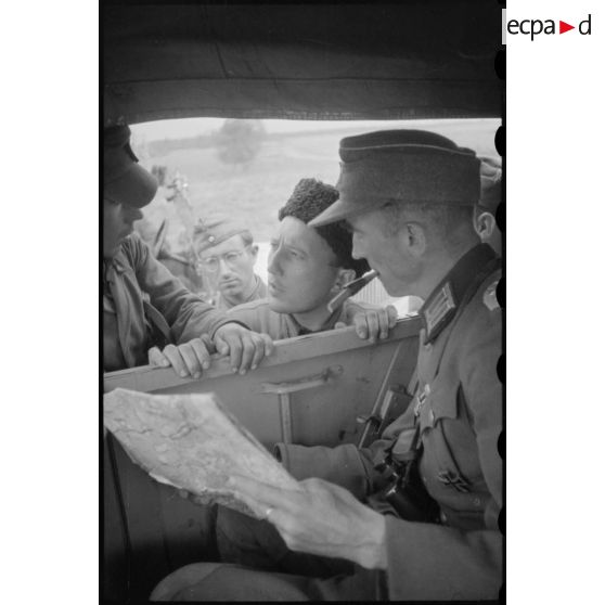 Un colonel cherche son chemin, il semble demander l'aide de soldats russes sous l'uniforme allemand.