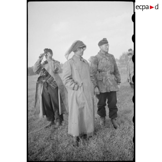 Portrait d'un colonel portant un monocle et oiffé d'une moustiquaire.