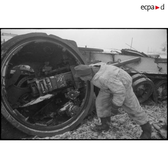 La tourelle renversée d'un T-34 suscite l'intérêt d'un Panzergrenadier allemand.
