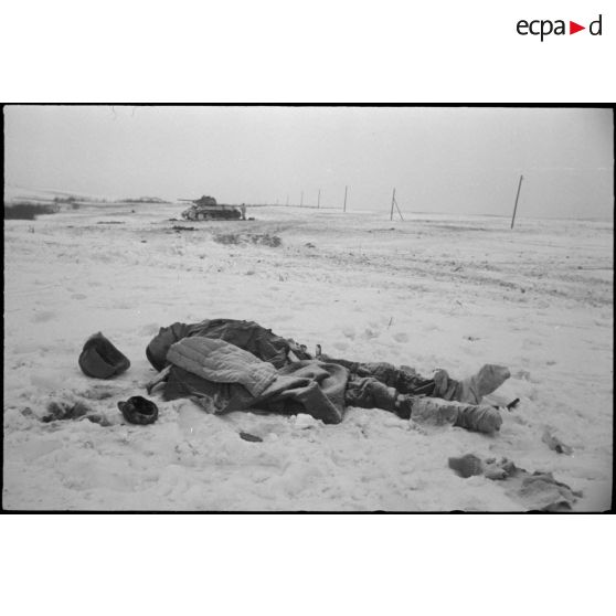 Un cadavre de soldat soviétique, au second plan, un T-34 détruit.