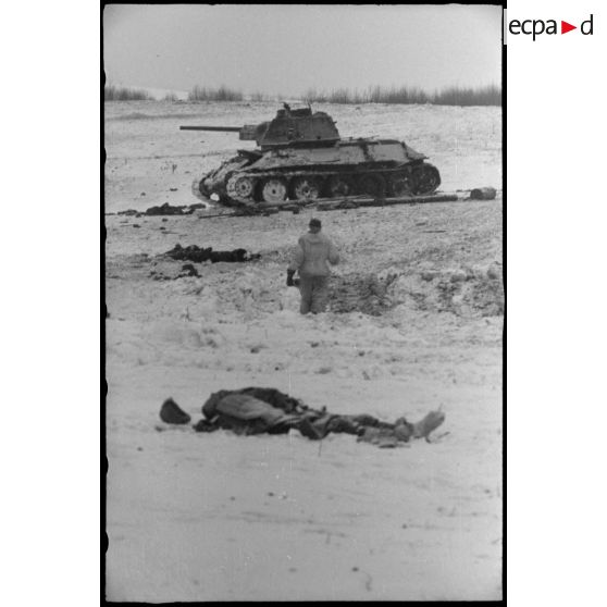 Un cadavre de soldat soviétique, au second plan, un T-34 détruit.