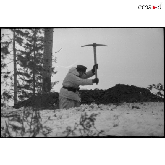 Un Panzergrenadier creuse une tranchée à la pioche.