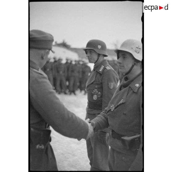 Le commandant (Major) Horst-Wolf Hoppe remet une décoration à des membres du schwere Panzerjäger-Abteilung 519.