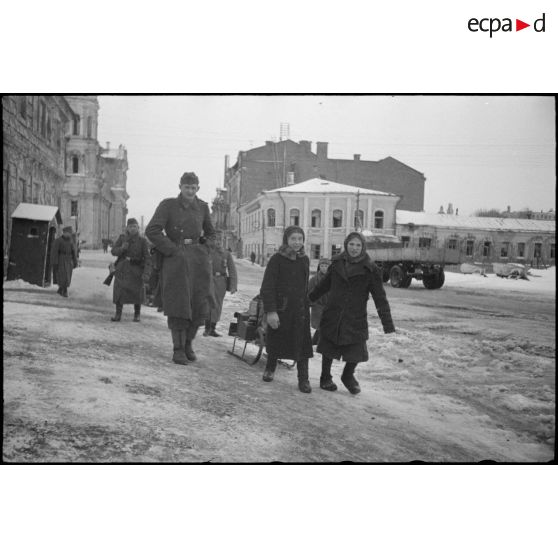 A Vitebsk (Witebsk), des permissionnaires allemands rejoignent leur affectation, un enfant tracte un traineau sur lequel sont installés l'équipement des fantassins.