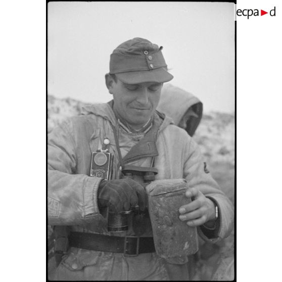 Un lieutenant (Leutnant) d'une unité de Panzergrenadier coupe une tranche de pain noir.
