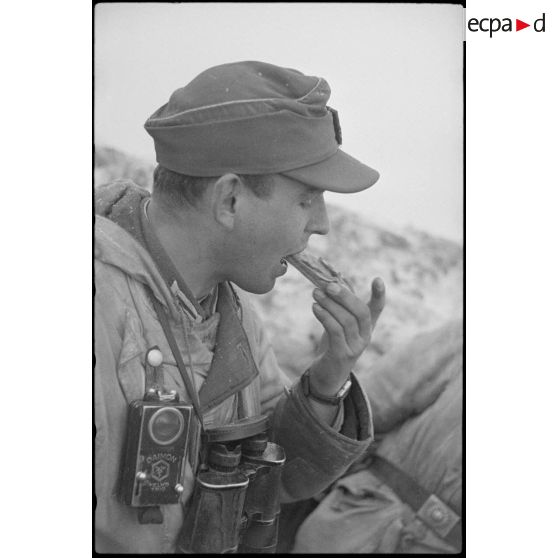 Un lieutenant (Leutnant) d'une unité de Panzergrenadier coupe une tranche de pain noir.