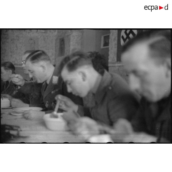Le général (Generalleutnant) Robert Pistorius partage un repas avec des hommes 4e division d'infanterie de l'armée de l'air allemande après avoir prononcé un discours.