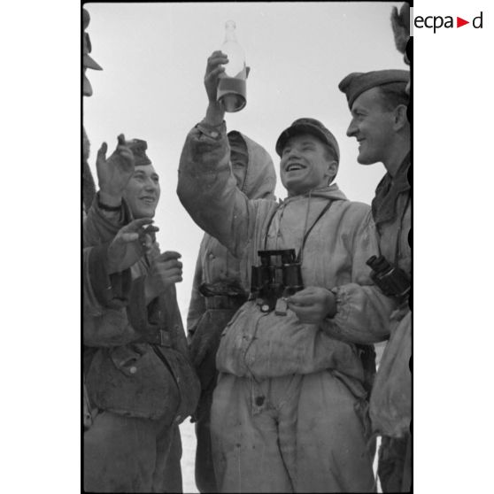 Des fantassins de la 4e division d'infanterie de l'armée de l'Air allemande (4. Luftwaffe Feld Division) partagent une bouteille.
