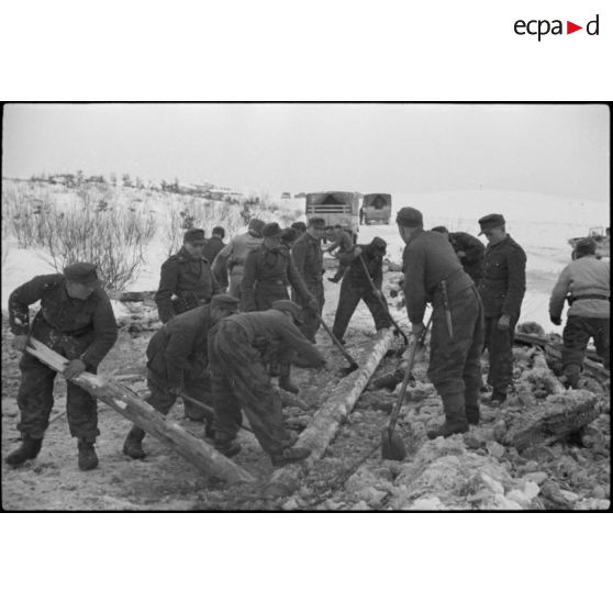 Pris dans la glace, les rondins qui consolidaient la route sont détruits à l'aide d'explosifs.