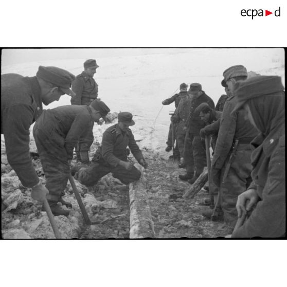 Pris dans la glace, les rondins qui consolidaient la route sont détruits à l'aide d'explosifs.