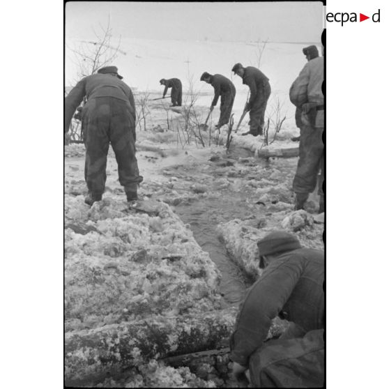 Pris dans la glace, les rondins qui consolidaient la route sont détruits à l'aide d'explosifs.