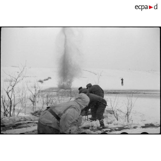 Pris dans la glace, les rondins qui consolidaient la route sont détruits à l'aide d'explosifs.