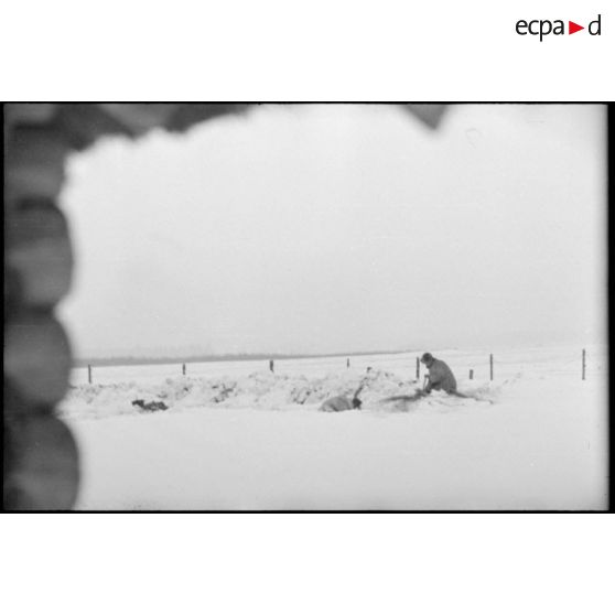 Des fantassins creusent des tranchées dans la neige fraiche.