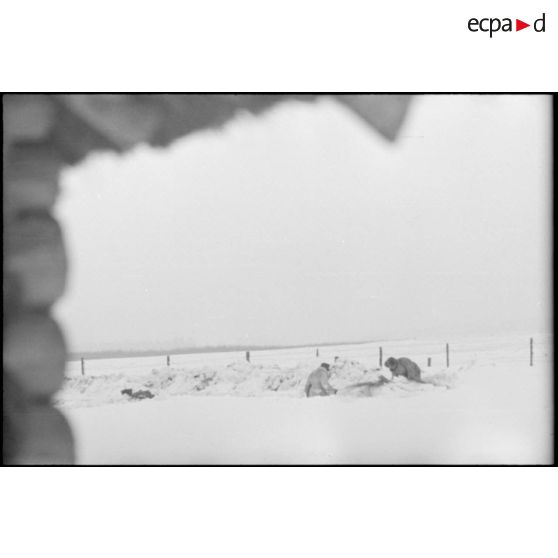 Des fantassins creusent des tranchées dans la neige fraiche.