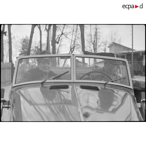 Le général (Generalleutnant) Rolf Wuthmann monte à bord d'une décapotable et quitte le quartier général où s'est déroulée une réunion.