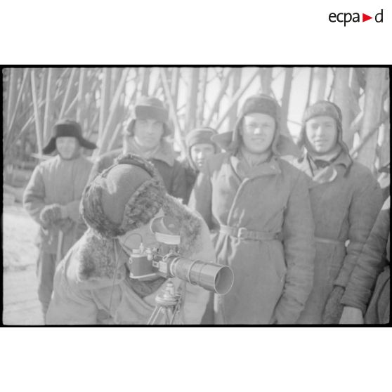 Un prisonnier soviétique, employé à la construction d'un pont, s'intéresse à l'appareil photographique Leica du reporter.