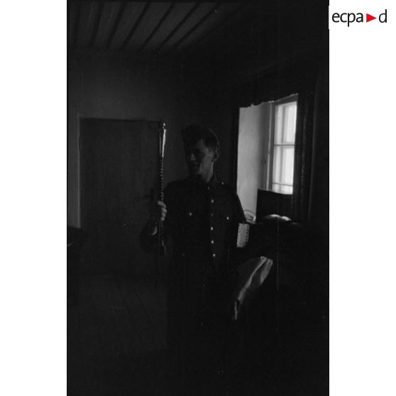 Un soldat vient d'emprunter le bâton de maréchal de Ernst Busch et joue avec, dans l'autre bras, une boite de cigares.