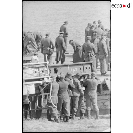 Déploiement de poutres métalliques du ponton (Brückegerät) pour faire descendre ou monter un véhicule.