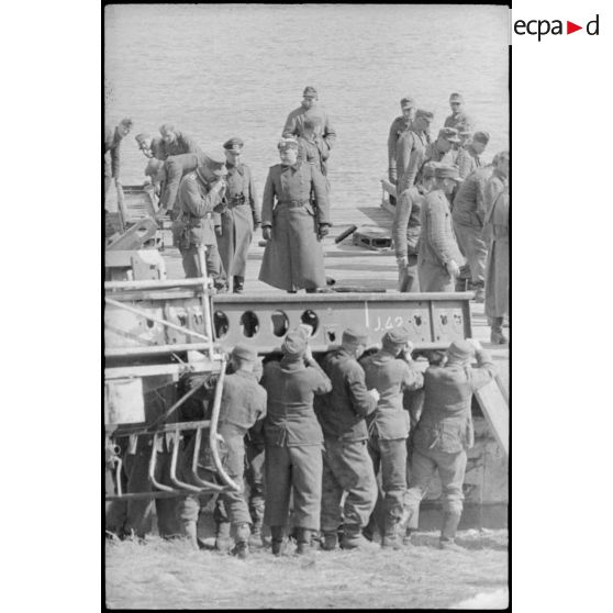 Déploiement de poutres métalliques du ponton (Brückegerät) pour faire descendre ou monter un véhicule.