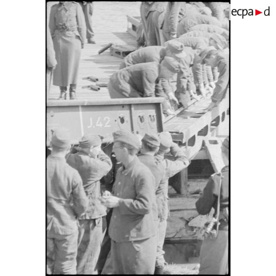 Déploiement de poutres métalliques du ponton (Brückegerät) pour faire descendre ou monter un véhicule.