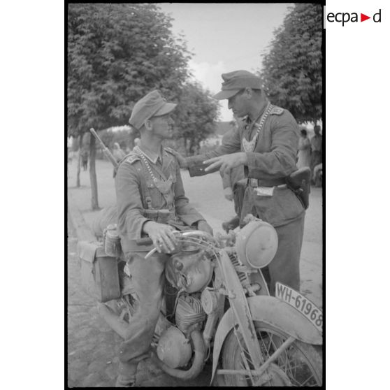 Deux Feldgendarme au milieu d'une rue lors de l'évacuation d'une ville lettone.