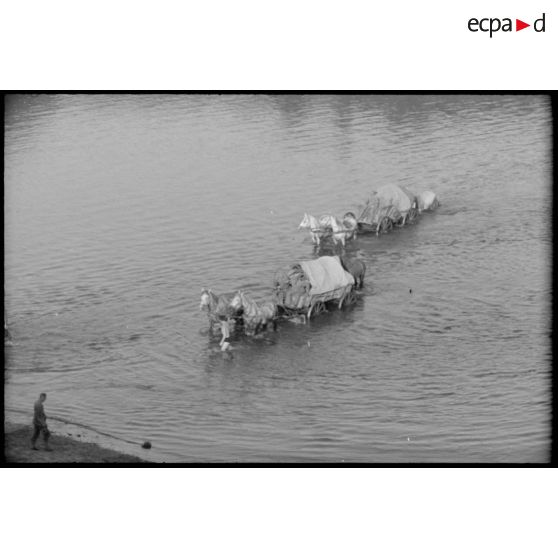 La traversée d'une rivière ou d'un fleuve par une charrette d'infanterie allemande en pleine retraite.