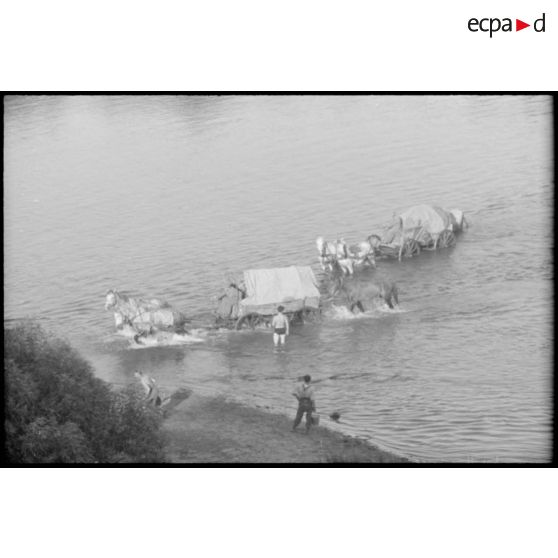 La traversée d'une rivière ou d'un fleuve par une charrette d'infanterie allemande en pleine retraite.