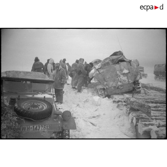 Kübelwagen immatriculée WH-1432 613 arrêtée alors qu'un semi-chenillé a versé d'un pont de bois.