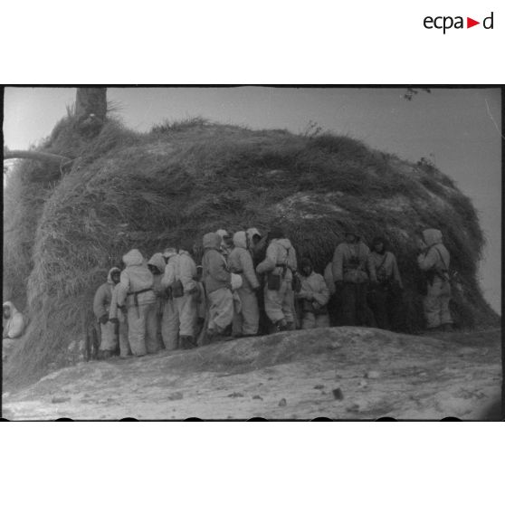 Des Panzergrenandiers camouflés derrière une meule de foin.