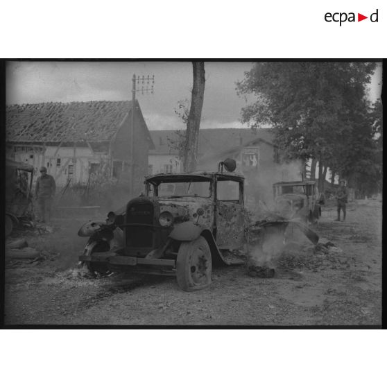 Plan général de la carcasse calcinée d'un camion détruit par le bombardement allemand du village.