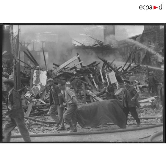 Des volontaires de la défense passive brancardent une victime tuée par le bombardement allemand.