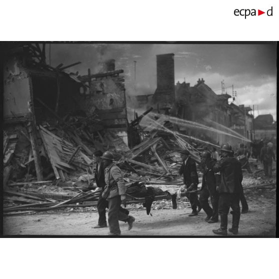 Des volontaires de la défense passive brancardent une victime tuée par le bombardement allemand.