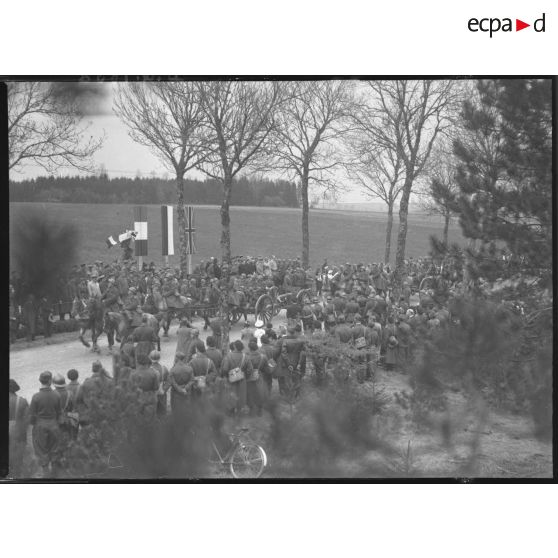 Sur une route, les troupes polonaises (75 mm M1897 hippomobile) défilent devant les officiels civils et militaires, polonais et français.