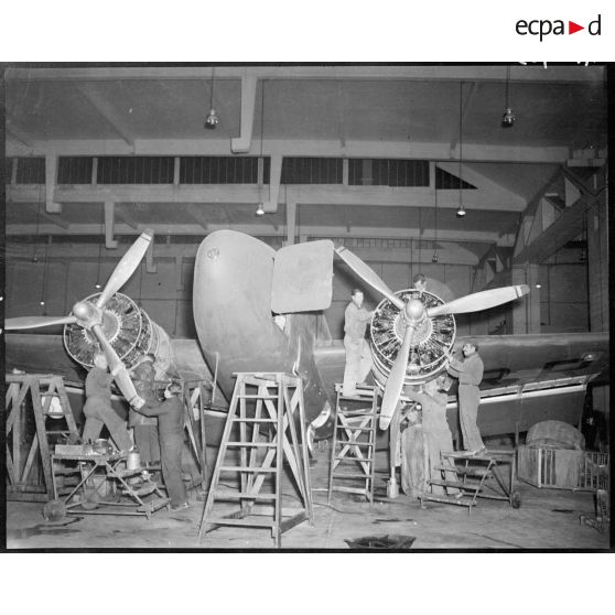 Révision de fond en comble d'un Lockheed 18 dans un hangar à Maison Blanche.