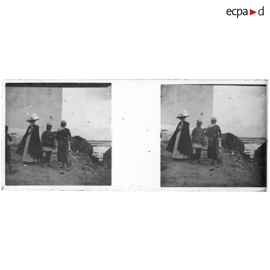 [Maroc : femme européenne en bord de mer avec indigènes]. [Légende d'origine]