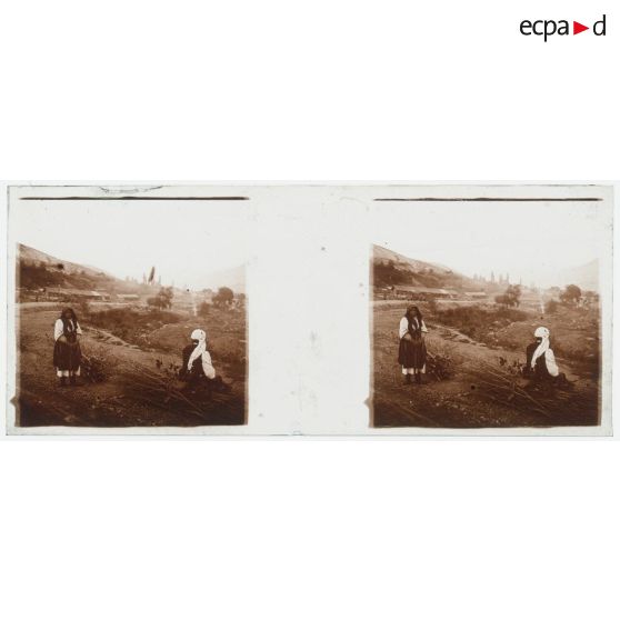 [Vie locale : deux  personnes avec des fagots de bois au bord d'une route].