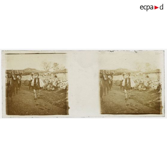 [Vie locale : groupe d'hommes dont un musicien sur une route].<br>